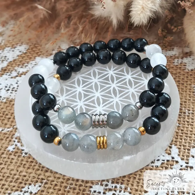 bracelet protection en pierres naturelles de lithothérapie, posé sur une fleur de vie, pierres : tourmaline noire, labradorite, selenite